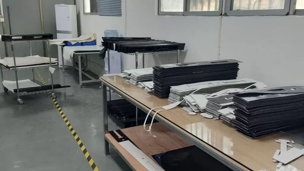 Fotografia scattata in officina che ritrae il materiale di rinforzo su un tavolo da taglio